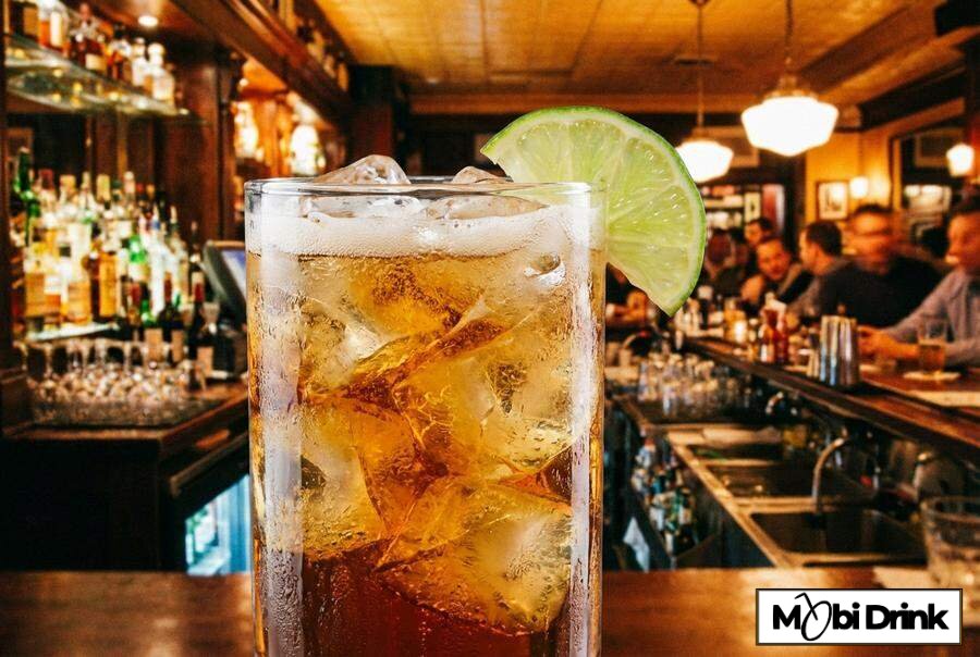 Szklanka z drinkiem Ballantines z colą i limonką