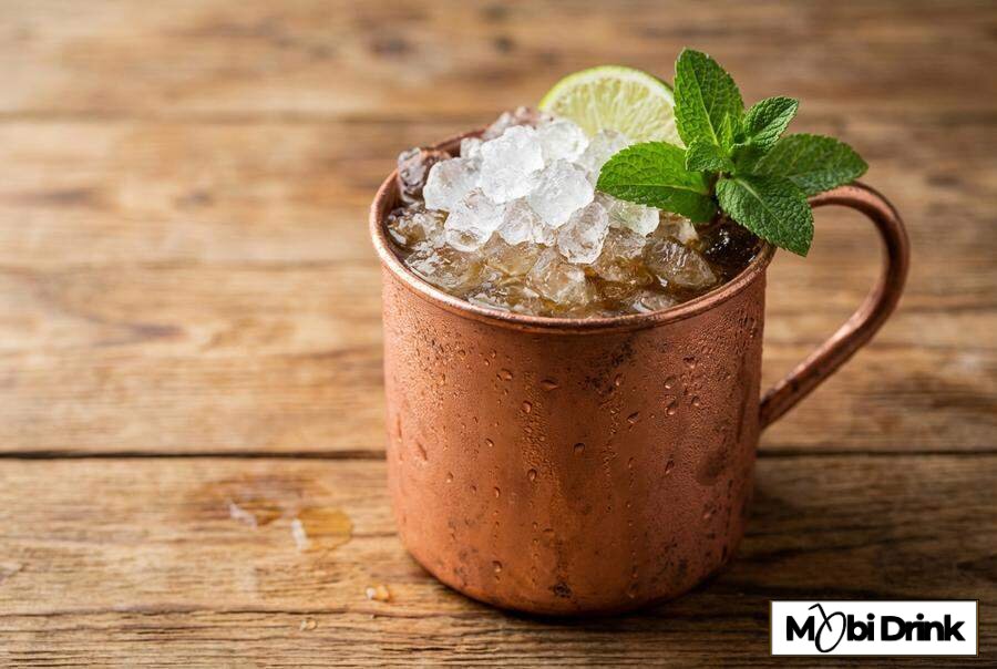Miedziany kubek z drinkiem Jäger Mule i limonką