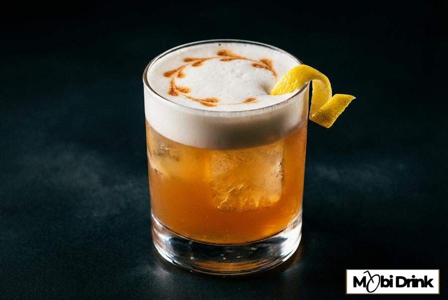 Klasyczny drink Whisky Sour z pianką i bittersem w szklance
