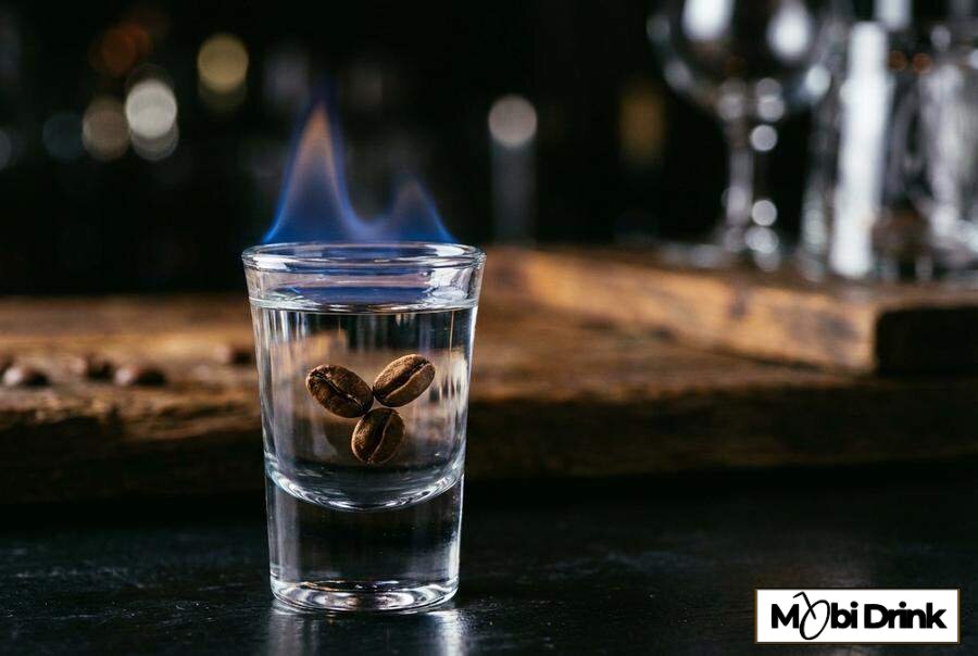 Płonący shot Sambuca con la mosca z ziarnami kawy