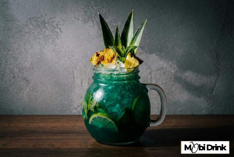 Turkusowy drink Sweet Poison z dekoracją z ananasa