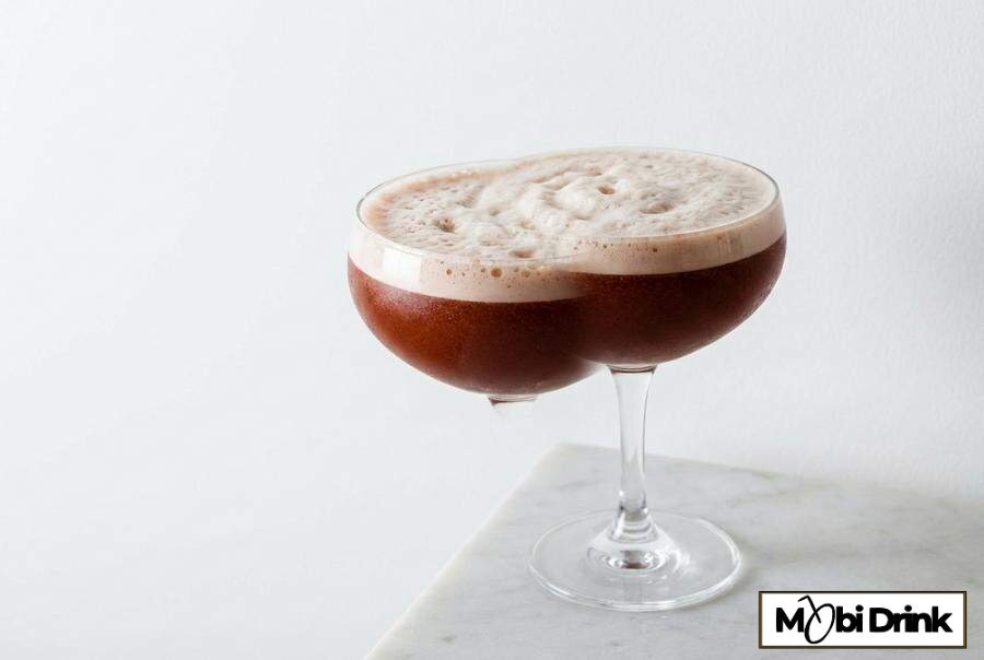 Ciemny drink Trinidad Sour z pianką w kieliszku