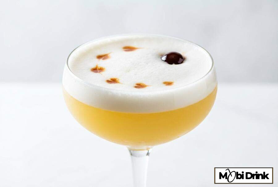 Koktajl Whiskey Sour z pianką i wisienką.